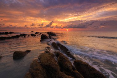 Deniz dalgası ile şaşırtıcı alacakaranlık deniz manzarası Kuala Penyu, Sabah, Borneo 'da yeşil yosunlara çarpıyor. Resim uzun pozlama nedeniyle yumuşak odak ve bulanıklık içerebilir.