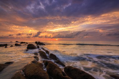 Deniz dalgası ile şaşırtıcı alacakaranlık deniz manzarası Kuala Penyu, Sabah, Borneo 'da yeşil yosunlara çarpıyor. Resim uzun pozlama nedeniyle yumuşak odak ve bulanıklık içerebilir.