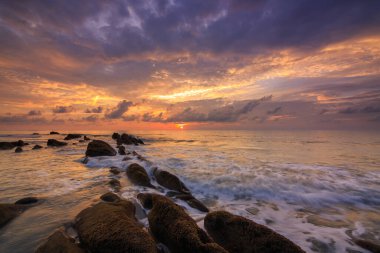 Deniz dalgası ile şaşırtıcı alacakaranlık deniz manzarası Kuala Penyu, Sabah, Borneo 'da yeşil yosunlara çarpıyor. Resim uzun pozlama nedeniyle yumuşak odak ve bulanıklık içerebilir.