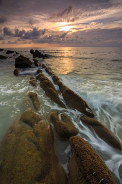 Deniz dalgası ile şaşırtıcı alacakaranlık deniz manzarası Kuala Penyu, Sabah, Borneo 'da yeşil yosunlara çarpıyor. Resim uzun pozlama nedeniyle yumuşak odak ve bulanıklık içerebilir.