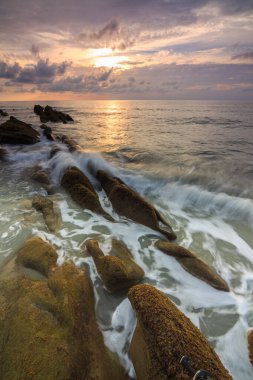 Deniz dalgası ile şaşırtıcı alacakaranlık deniz manzarası Kuala Penyu, Sabah, Borneo 'da yeşil yosunlara çarpıyor. Resim uzun pozlama nedeniyle yumuşak odak ve bulanıklık içerebilir.