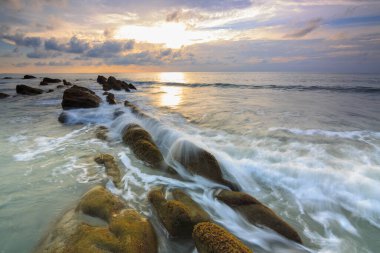 Deniz dalgası ile şaşırtıcı alacakaranlık deniz manzarası Kuala Penyu, Sabah, Borneo 'da yeşil yosunlara çarpıyor. Resim uzun pozlama nedeniyle yumuşak odak ve bulanıklık içerebilir.