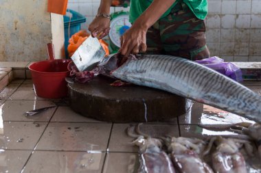 Kimliği belirsiz balıkçı Kota Kinabalu 'daki taze balık pazarında balık kesiyor. -