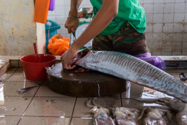 Kimliği belirsiz balıkçı Kota Kinabalu 'daki taze balık pazarında balık kesiyor. -