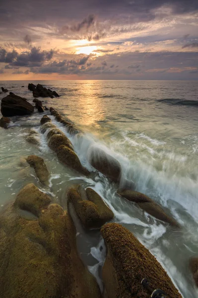 Deniz dalgası ile şaşırtıcı alacakaranlık deniz manzarası Kuala Penyu, Sabah, Borneo 'da yeşil yosunlara çarpıyor. Resim uzun pozlama nedeniyle yumuşak odak ve bulanıklık içerebilir.