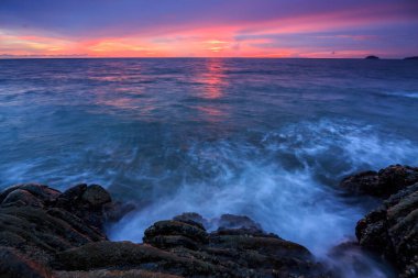 Günbatımı Alacakaranlık Borneo-Doğa konseptinde kayaların üzerinden okyanus akışı