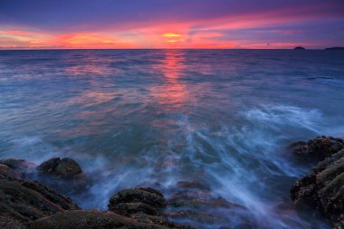Günbatımı Alacakaranlık Borneo-Doğa konseptinde kayaların üzerinden okyanus akışı