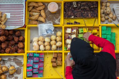 Kota Kinabalu. Sabah, Malezya - CIRCA JULY, 2017: Gıda satıcısı, Kota Kinabalu, Sabah 'daki gıda tezgahında çeşitli malay ev yapımı yerel pastalar veya 
