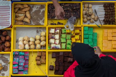 Kota Kinabalu. Sabah, Malezya - CIRCA JULY, 2017: Gıda satıcısı, Kota Kinabalu, Sabah 'daki gıda tezgahında çeşitli malay ev yapımı yerel pastalar veya 