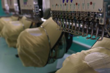 Kumaş Üreticilerinde Tekstil Endüstrisinde nakış makinesi iğnesi, nakış başlığı, iğne ipliği (seçici odaklanma ve yumuşak odaklanma))