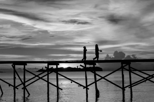 马来西亚沙巴州Kota Belud市Mantanani岛 一个轮廓鲜明的孩子在日落时分高兴地在木制的码头上奔跑 — 图库照片