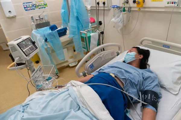 Kota Kinabalu, Sabah, Malezya - 30 Mayıs 2020: Hastane doğum odası koğuşunda doğum sancısı çeken genç Asyalı kadın bebek doğurmayı bekliyor