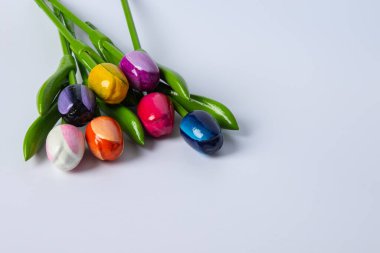 Beyaz arkaplanda kristal bir vazoda renkli laleler