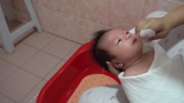 Bakış açısına göre, yeni doğan erkek bebek, yeni doğan bebek için anne, hijyen ve sağlık hizmetleriyle banyo yapıyor..