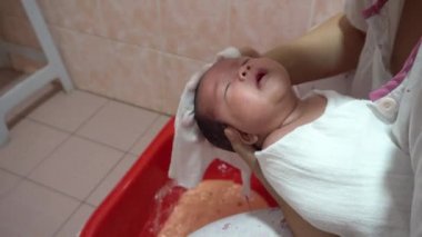 Bakış açısına göre, yeni doğan erkek bebek, yeni doğan bebek için anne, hijyen ve sağlık hizmetleriyle banyo yapıyor..