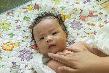 Yatakta yatan Asyalı şirin bir bebeğin portresi.