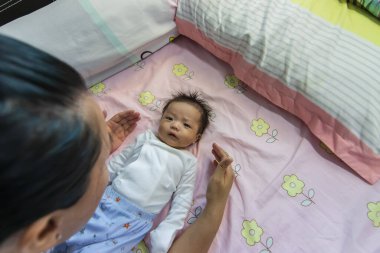 Yatakta yatan Asyalı şirin bir bebeğin portresi.