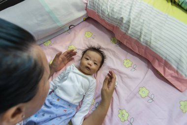 Yatakta yatan Asyalı şirin bir bebeğin portresi.