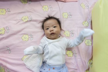 Yatakta yatan Asyalı şirin bir bebeğin portresi.
