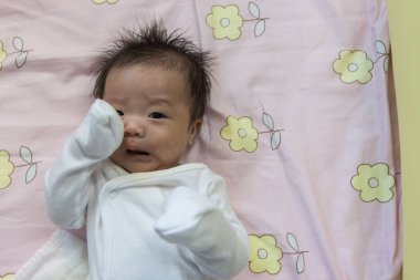 Yatakta yatan Asyalı şirin bir bebeğin portresi.