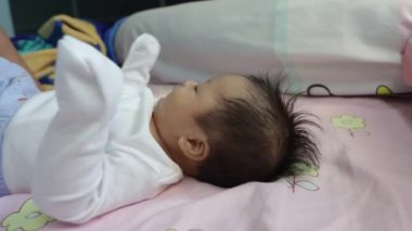 Sevimli çocuğun gülümseyen ve oynayan, kameraya yakından bakan yerel hayat tarzı. Çocuk, bebek, ebeveynlik, çocukluk, hayat, annelik, annelik kavramı.
