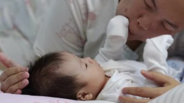 Çinli genç anne, yeni doğmuş bebeğiyle odada oynarken yerel yaşam tarzını yakından çekiyor. Çocuk, bebek, ebeveynlik, çocukluk, hayat, annelik, annelik kavramı