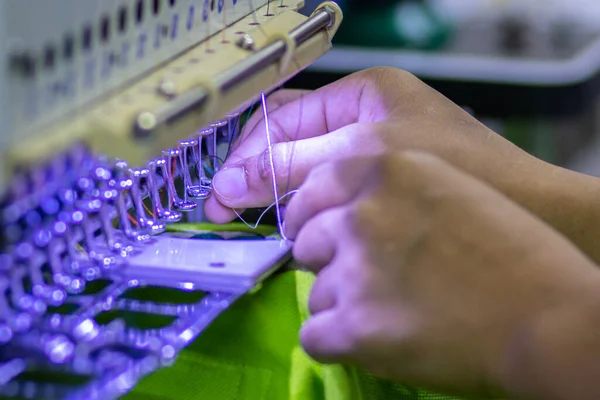 Bir el iğneyi nakış iğnesine batırdı.