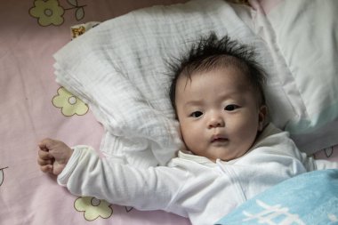 Sevimli çocuğun yerel yaşam tarzı gülümseyen ve kameraya yakından bakan. Çocuk, bebek, ebeveynlik, çocukluk, hayat, annelik, annelik kavramı