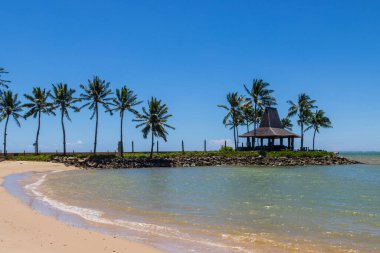Kota Kinabalu Plajı, Sabah, Malezya 'da açık mavi gökyüzü üzerinde sahil ve palmiye ağaçları