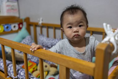 Küçük kız onun yatağında duruyor ve mutluluktan gülümsüyor.