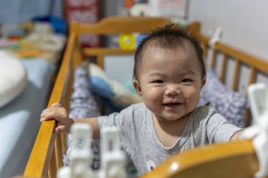 Küçük kız onun yatağında duruyor ve mutluluktan gülümsüyor.