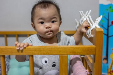 Küçük kız onun yatağında duruyor ve mutluluktan gülümsüyor.