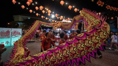 Kota Kinabalu, Sabah, Malezya - 16 Şubat 2024: Çin Yeni Yıl kutlamaları sırasında geleneksel kıyafet giymiş bir grup insan sokakta ejderha dansı yapıyor