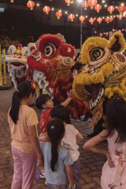 Kota Kinabalu, Sabah, Malezya - 17 Şubat 2024: Çin Yeni Yıl kutlamaları sırasında havai fişeklerle aslan dansı yapan kalabalık