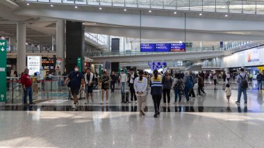 Hong Kong, Çin - 21 Mart 2024: Hong Kong Uluslararası Havaalanı 'ndaki varış salonunda bavullu turist grubu