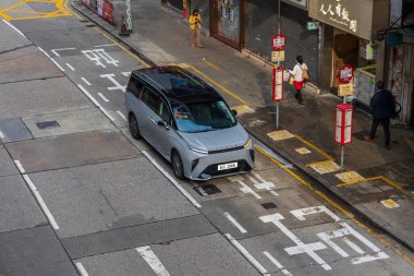 Hong Kong, Çin - 22 Mart 2024: Çin 'in Hong Kong şehrinde şehir içi ulaşımı sergilenen boş bir caddede modern elektrikli araba