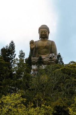 Mars bronz Buda heykeli bulutların üstündeki bir dağın tepesinde huzur içinde duruyor ve etrafı yeşil ormanlarla çevrili.
