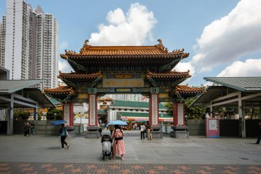 Hong Kong, Çin - 24 Mart 2024: Güneşli bir günde Çin 'in Hong Kong kentindeki Wong Tai Sin tapınağına giren turistler