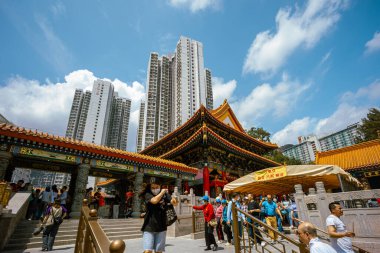 Hong Kong, Çin - 24 Mart 2024: Koruma maskesi takan turistler ve yerliler Hong Kong 'daki Wong Tai sin Tapınağı' nda tütsü çubuklarıyla dua ediyorlar.