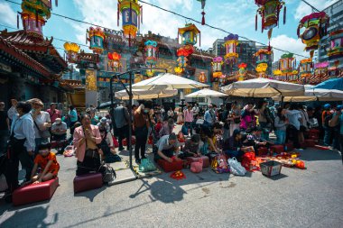 Hong Kong, Çin - 24 Mart 2024: Koruma maskesi takan turistler ve yerliler Hong Kong 'daki Wong Tai sin Tapınağı' nda tütsü çubuklarıyla dua ediyorlar.