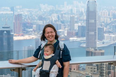 Hong Kong 'da güneşli bir günün tadını çıkaran Asyalı bir aile fotoğraf için poz veriyor.