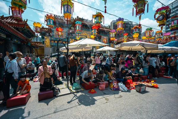 Hong Kong, Çin - 24 Mart 2024: Koruma maskesi takan turistler ve yerliler Hong Kong 'daki Wong Tai sin Tapınağı' nda tütsü çubuklarıyla dua ediyorlar.