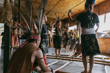 Penampang, Sabah, Malezya - 30 Mayıs 2024: Kaamatan Festivali sırasında geleneksel Kadazan Dusun Murut kostümlü bambu dans gösterisi giymiş gülümseyen bir grup genç kadın.