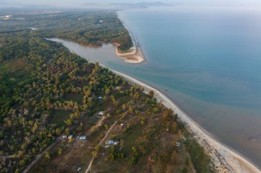 Nefes kesen hava perspektifi bir nehrin yakınlaşmasını gösteriyor, yemyeşil orman, ve resim gibi bir okyanus kıyısı boyunca el değmemiş kumlu sahil.