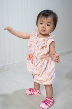 Sevimli küçük kız ilk adımlarını parlak bir odada atıyor, etrafındaki dünyayı keşfediyor.