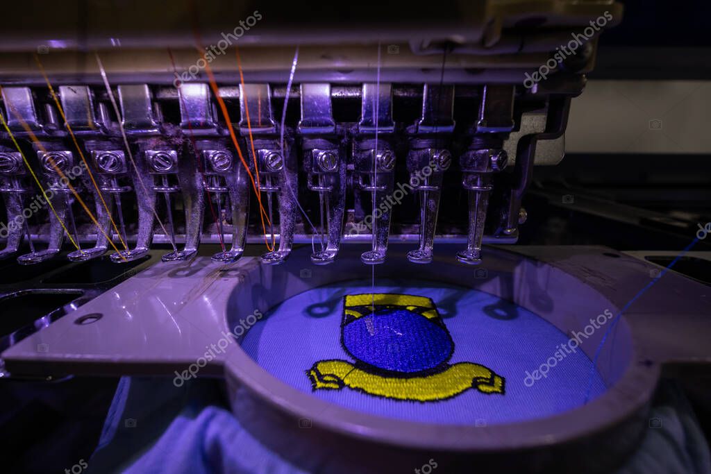 Close-up of Worker hand putting embroidery thread into embroidery needle at textile Industry at Garment Manufacture