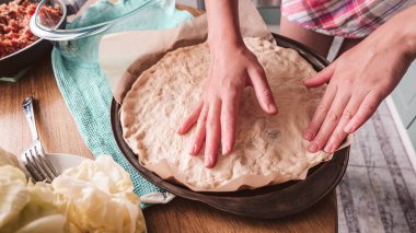 Mozzarella 'lı ev yapımı pizza ve fesleğenli jambon. Tahta bir masanın üstünde..