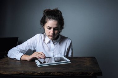 Gözlüklü kız evde bilgisayarla çalışıyor ve çevrimiçi yayın yapıyor. Tahta masadaki kız. Yaratıcı kız.  