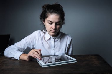 Gözlüklü kız evde bilgisayarla çalışıyor ve çevrimiçi yayın yapıyor. Tahta masadaki kız. Yaratıcı kız.  