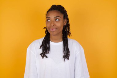 Afro-Amerikalı kadın sarı arka plana bakıyor. 